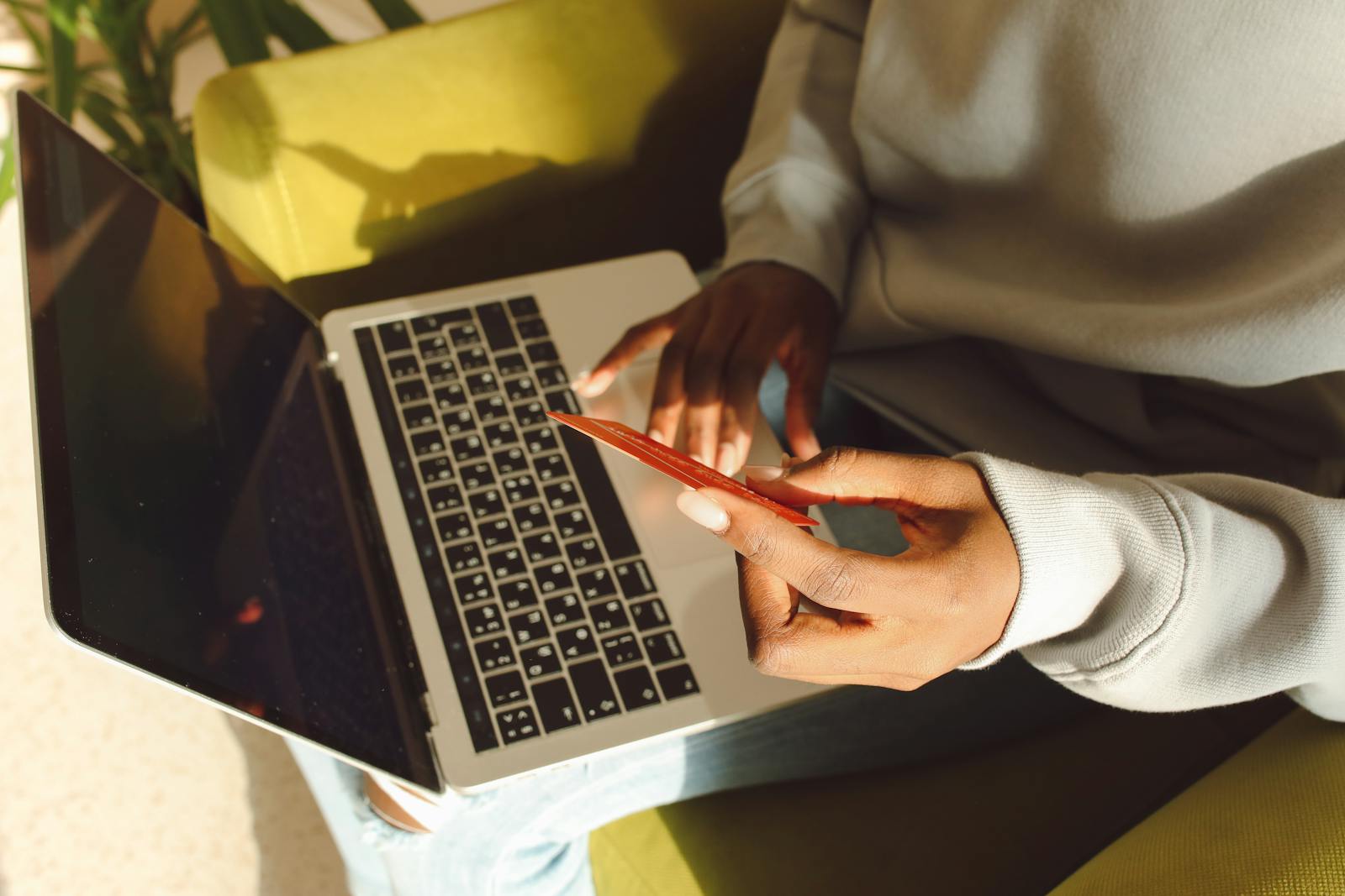 A customer using digital banking on a laptop while holding a payment card